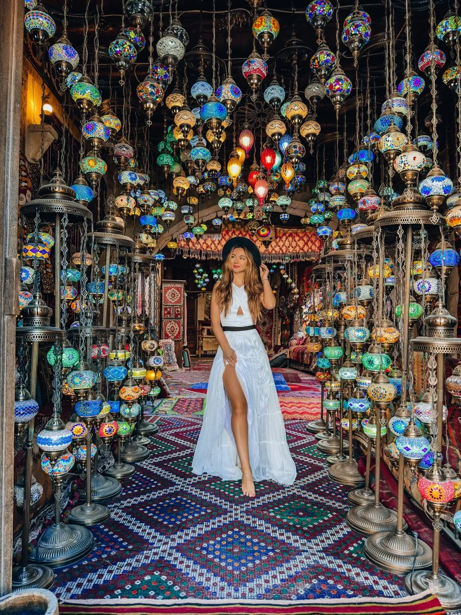 Woman walking through a lantern-filled market interior in Istanbul